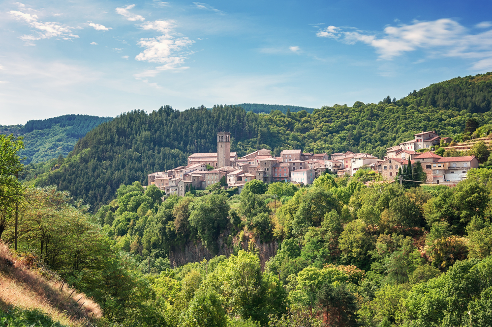 het roze gekleurd dorpje Antraigues-sur-Volane, gelegen op een plateau te midden van de beboste bergen in de Ardèche
