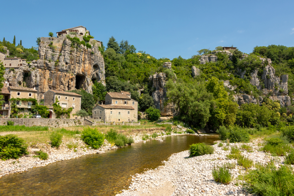 huizen gelegen tussen een rivier en een rotswand in het dorpje Labeaume in de Ardèche