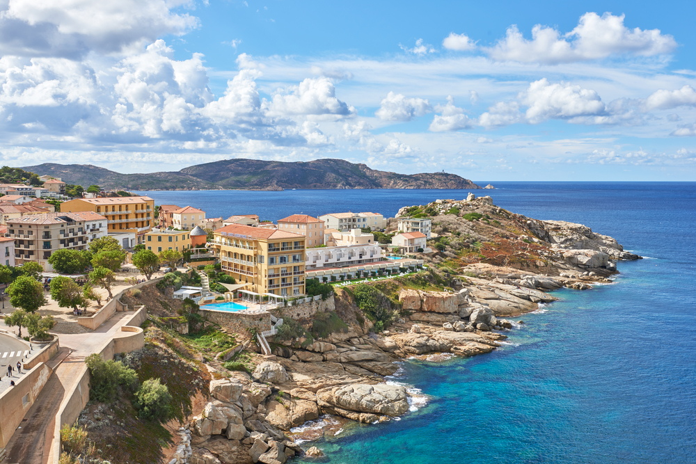 het kleurrijke dorpje Calvi met appartementencomplexen met zwembaden gelegen aan de rotsachtige kust van Corsica
