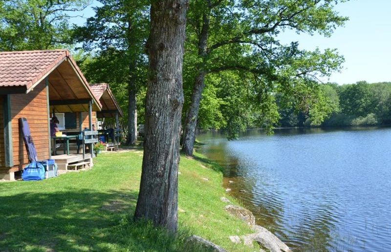 houten chalets glegen aan een meer met bomen