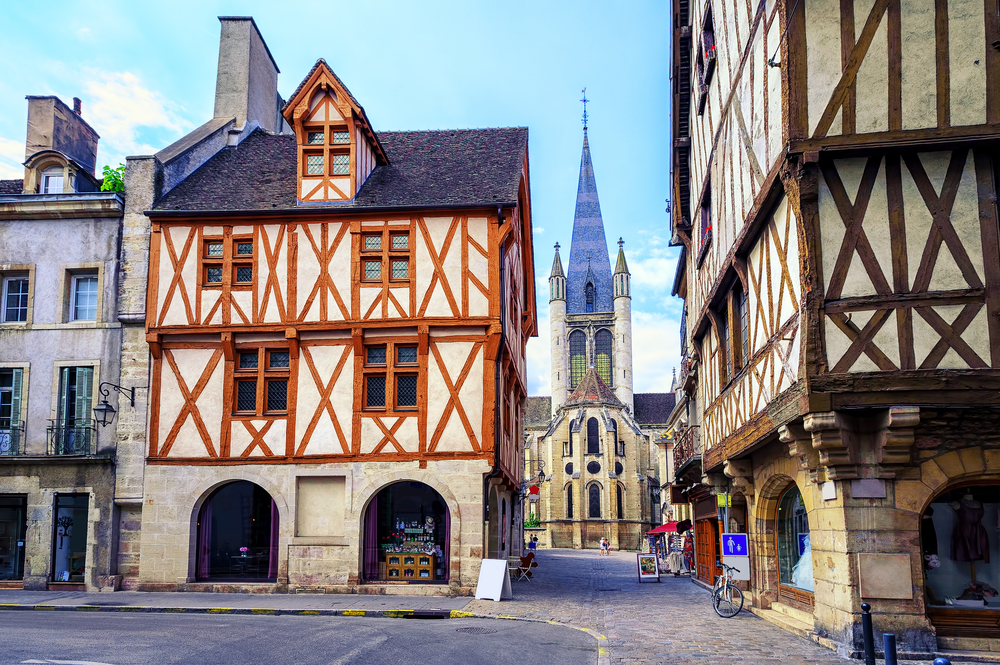 vakwerkhuizen en daartussen een straat met aan het einde een kerk in Dijon, Frankrijk