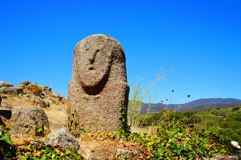 grote steen met de vorm van een gezicht in een groen landschap op de archeologische vindplaats Filitosa op Corsica