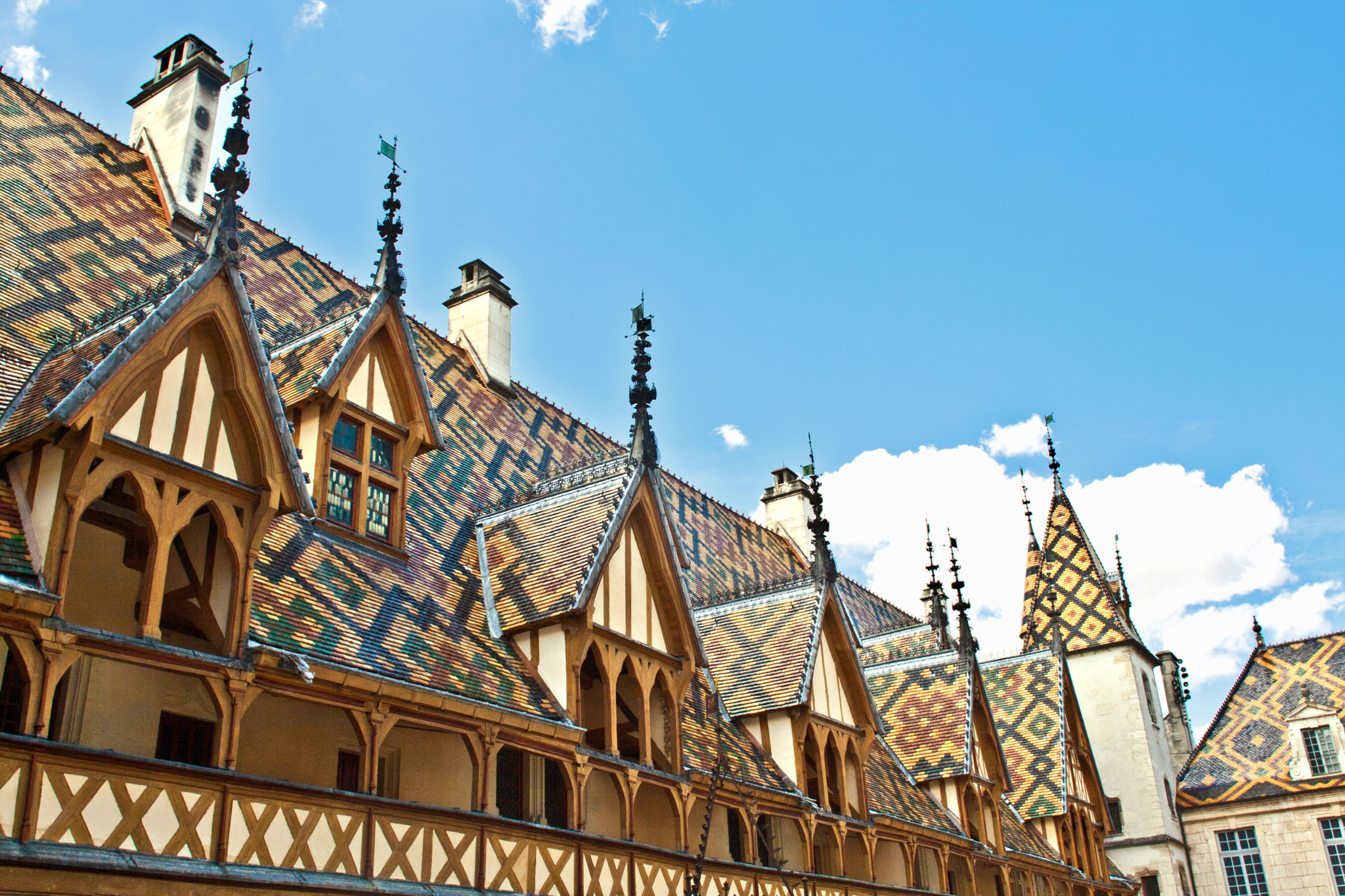 het dak van het Hospices de Beaune met torentjes en kleurrijke tegels met geometrische patronen 