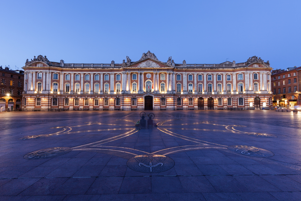 het verlichte stadhuis van Toulouse op het Place du Capitole bij schemering