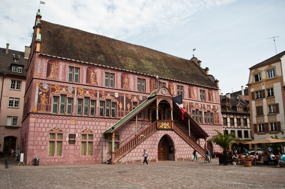 het roze stadhuis van Mulhouse met versierde voorgevel aan beide kanten van de ingang een hoge trap