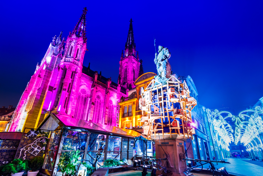 verlichte kerk en straat tijdens de kerstmarkt in Mulhouse