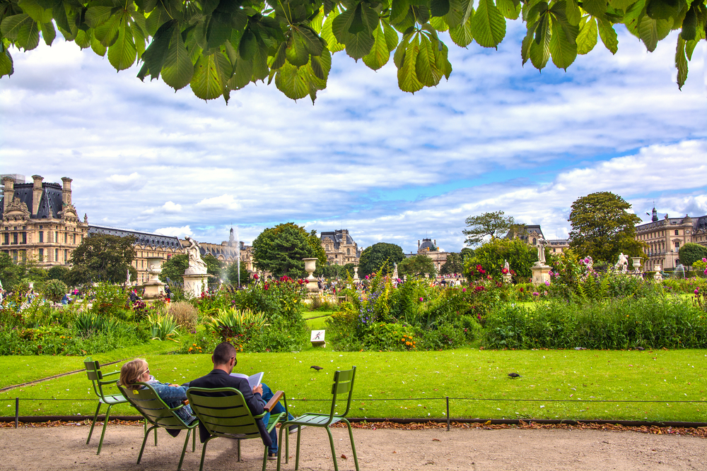 twee mensen die op groene stoelen zitten in de Jardin des Tuileries in Parijs op een wat bewolkte dag