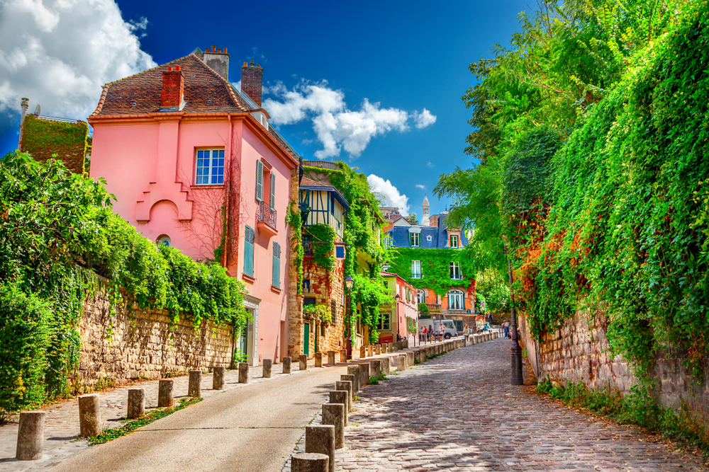 kleurrijke huizen en begroeide muren in een straat in de wijk Montmartre in Parijs