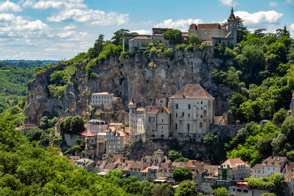 het stadje Rocamadour gelegen tegen een rotswand, op een licht bewolkte dag.