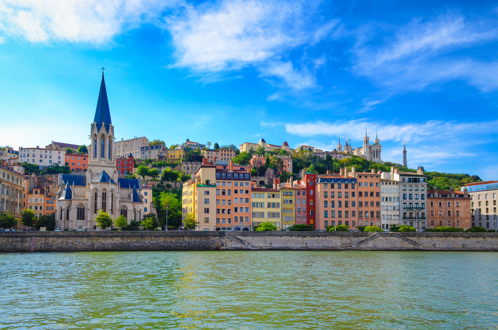 gekleurde huizen en een kathedraal in Vieux-Lyon, gezien vanaf een rivier