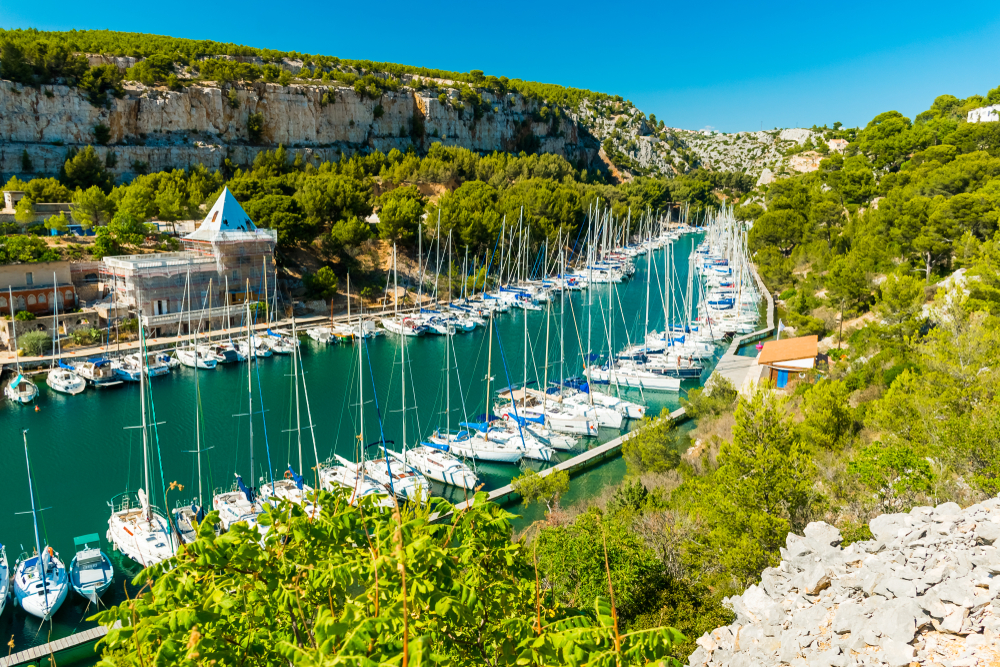 tientallen bootjes die op een rij liggen langs beide kanten van de Calanque Port-Miou