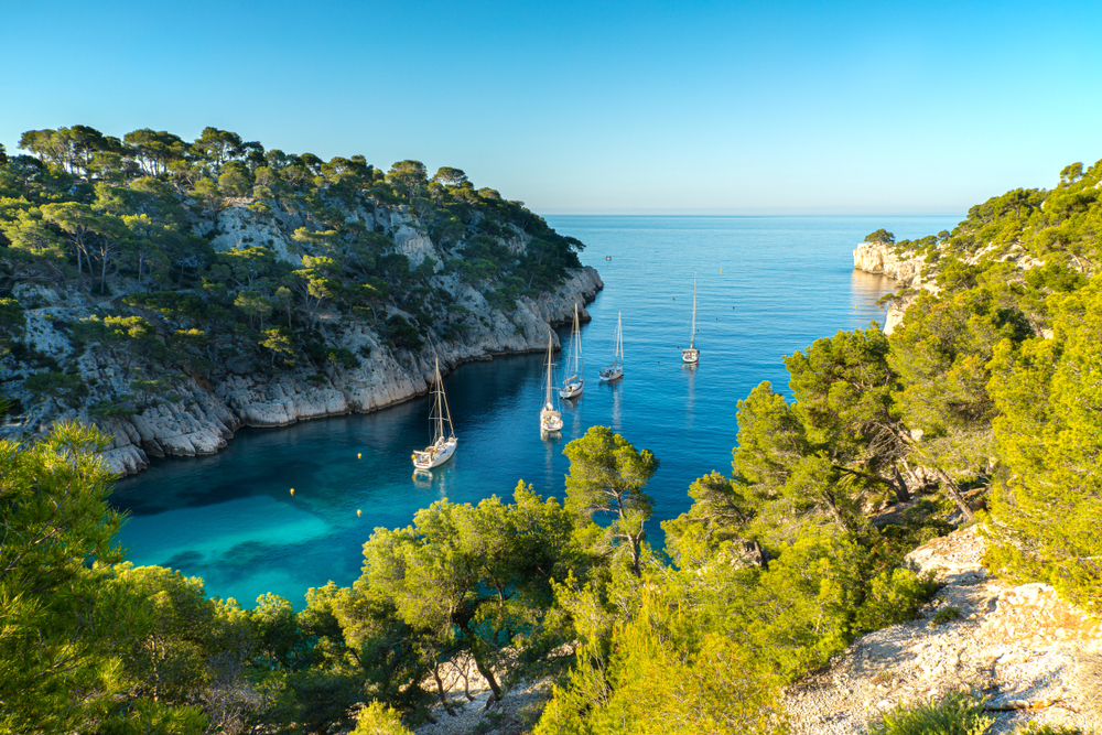 vijf bootjes op het helderblauwe water van de Calanque de Port-Pin