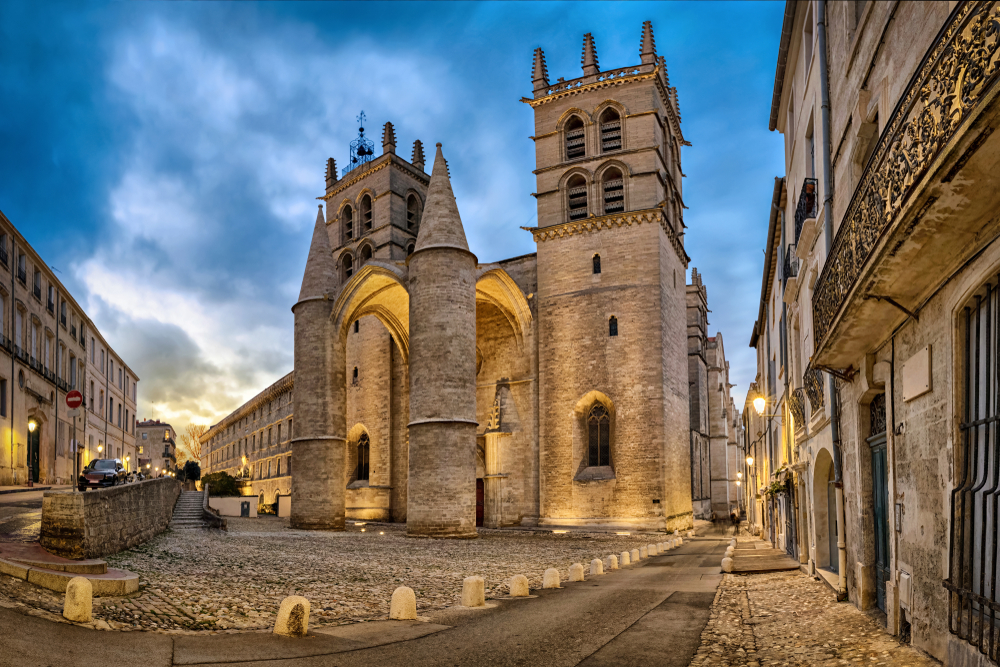 de gotische kerk Cathédrale Saint-Pierre en de daaromheen liggende smalle straatjes in Montpellier bij schemering 