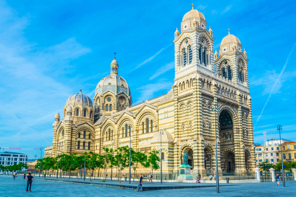 Grote kerk met gestreepte buitenkant en verschillende torens en koepels.