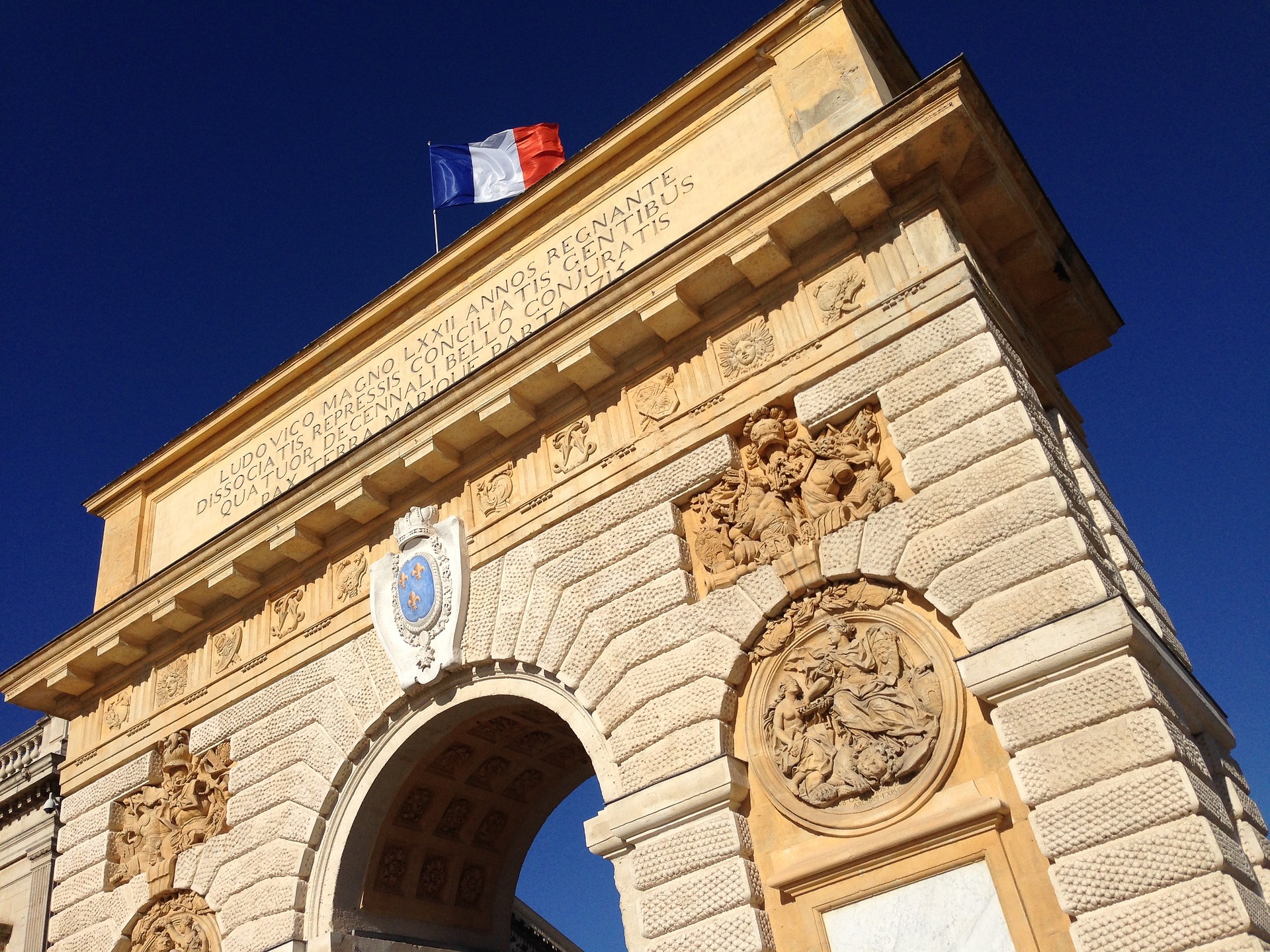 bovenste gedeelte van de Porte du Peyrou in Montpellier met bovenop de Franse vlag