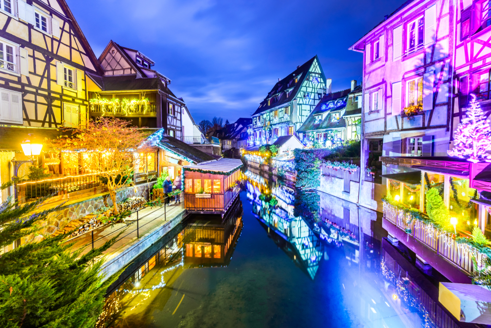 kanaal tijden de kerst in Colmar met an beide kanten in diverse kleuren verlichte vakwerkhuizen