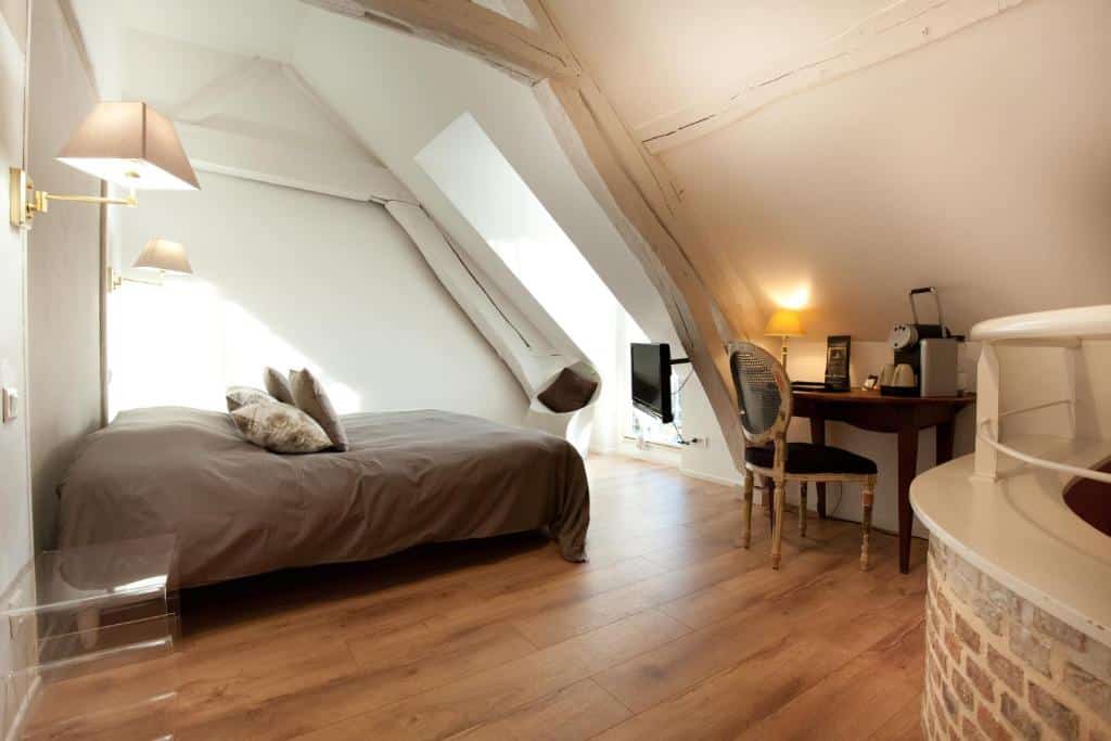 hotelkamer met twee persoonsbed en een bureau met antieke stoel in Hotel Le Prieuré et La Résidence in Amiens