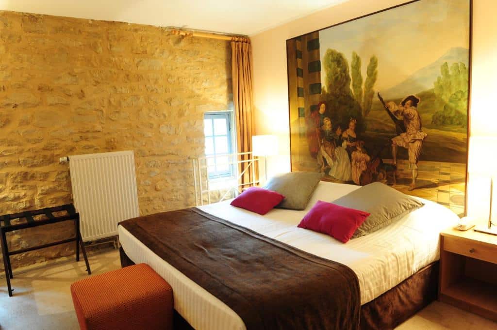 hotelkamer met een tweepersoonsbed en een groot schilderij aan het hoofdeinde in  een middeleeuws kasteel in Sedan, Champagnestreek