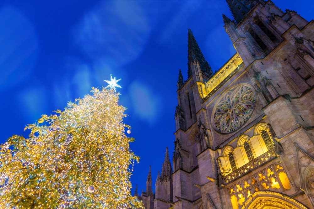 verlichte kerstboom en kathedraal in Bordeaux gezien van schuin-onderaf