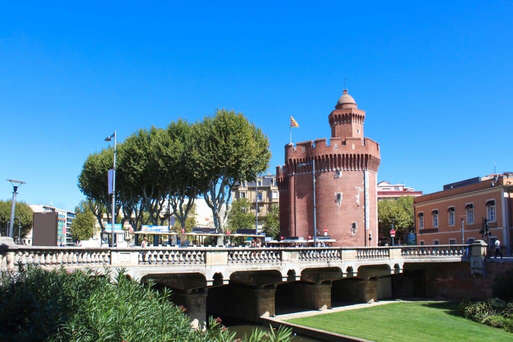 het 14e-eeuwse fort Le Castillet in Perpignan met op de voorgrond een brug met treintje