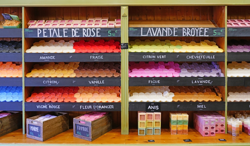 Verschillende kleuren en vormen zeepjes met namen en prijzen erbij, gelegen in de schappen van het Zeepmuseum.