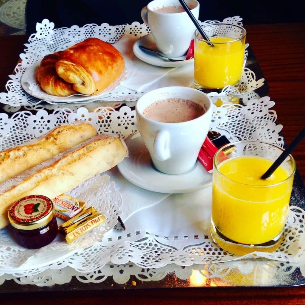 Ontbijtje met chocomelk, jus d'orange, stokbroodjes en jam
