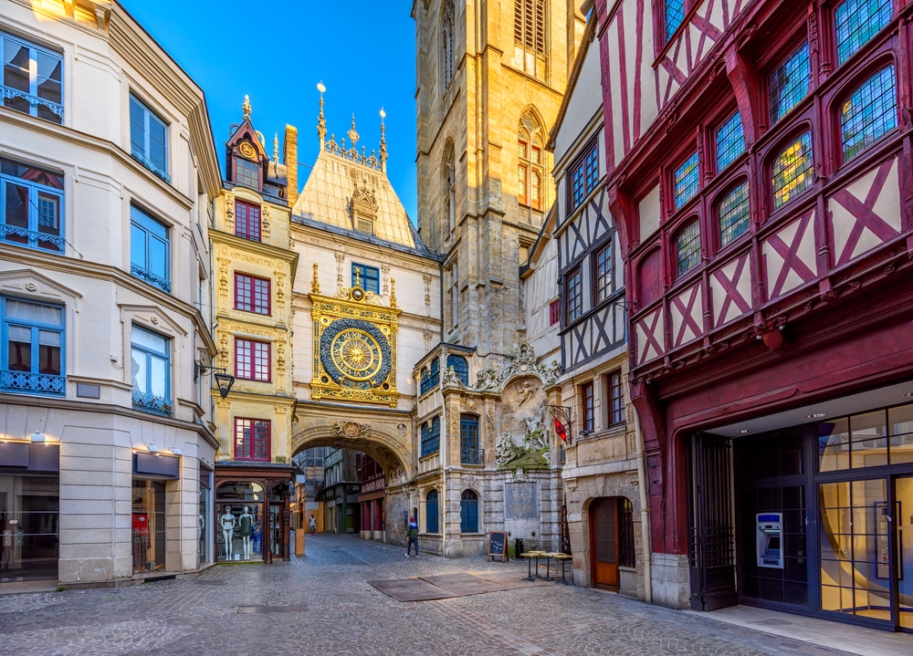 Plein van Rouen met in het midden de grote gouden 14-eeuwse klok van Rouen. Omgeven door vakwerkhuizen.