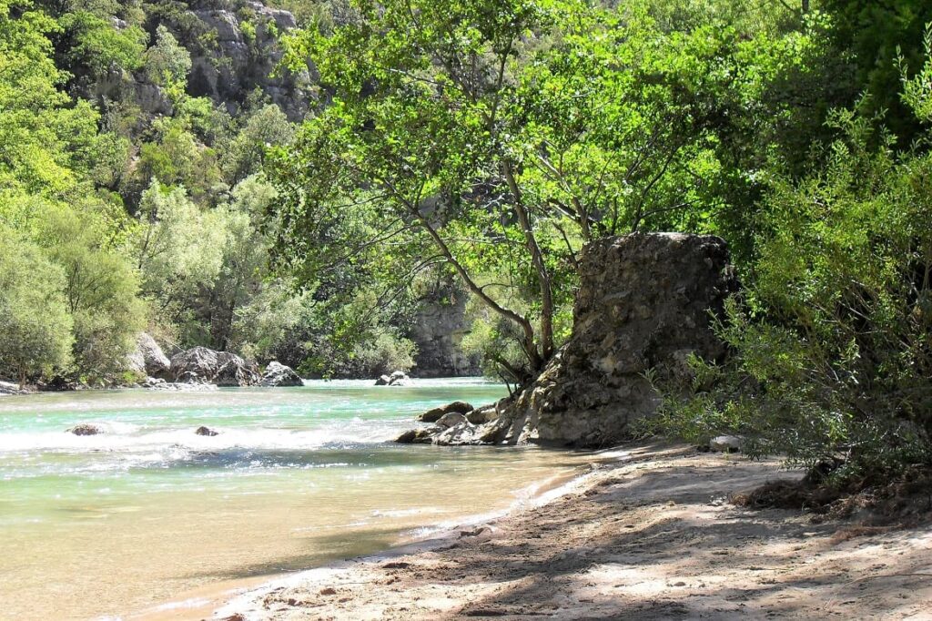 Stromende rivier de Verdon, omgeven door zand, rotsen en bomen