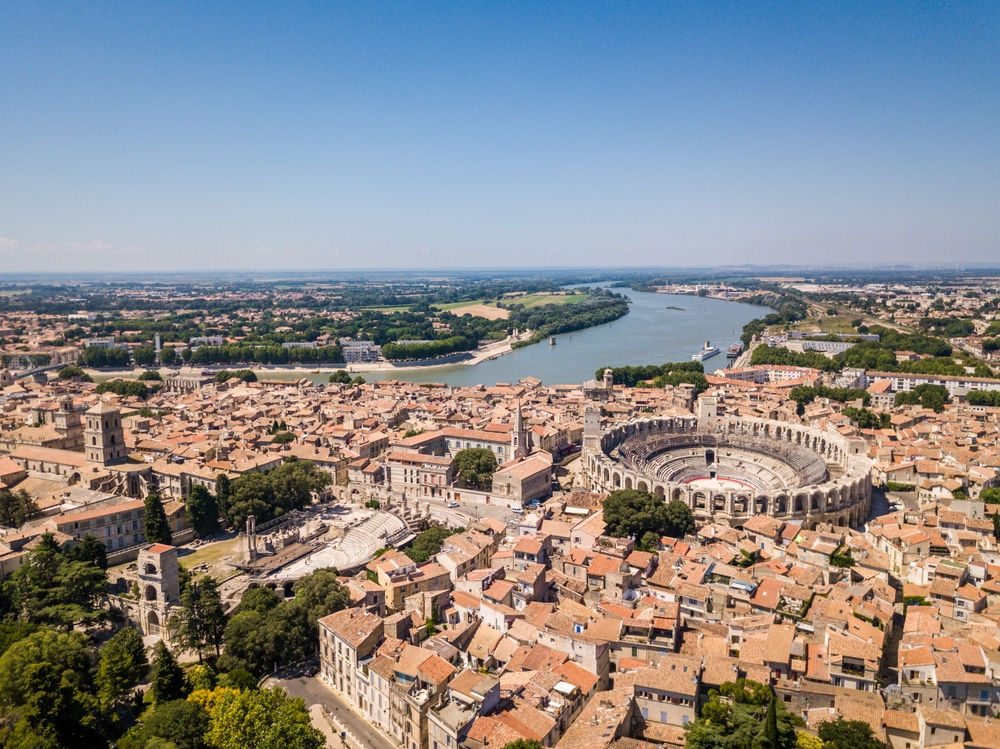 Panoram auitzicht een rivier, daken van huizen en het stenen amfitheater van de stad Arles