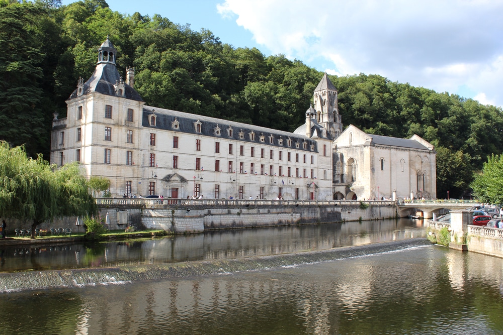 Groot wit kasteel gelegen aan het water en omringd door bossen in Brantôme.