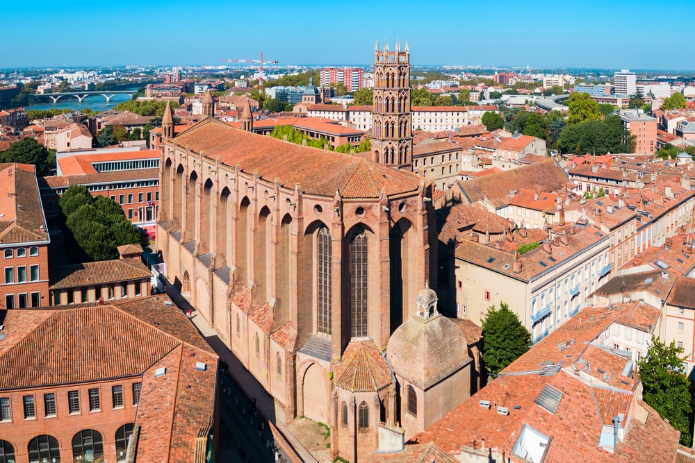 het klooster Couvent des Jacobins in Toulouse gezien van bovenaf met op de achtergrond vele gebouwen in de stad en de rivier Garonne