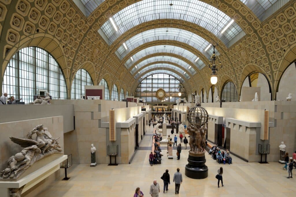 binnenkant van het Mussée d'Orsay in Parijs. Er lopen redelijk wat mensen rond en achterin hangt de bekende klok.