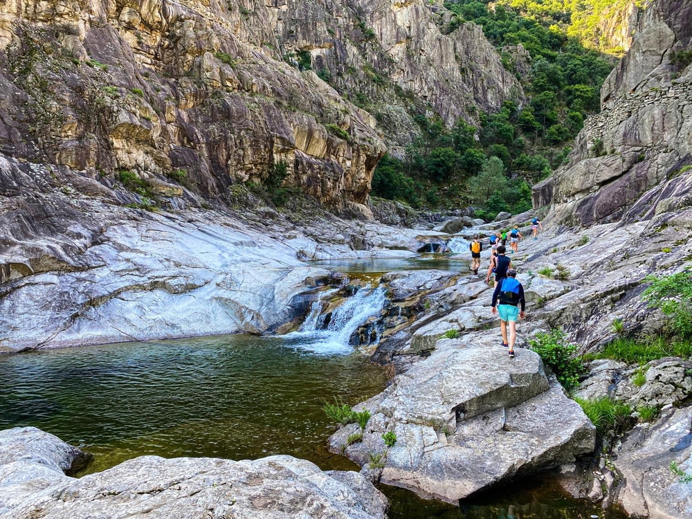 mensen die wandelen over stenen in een kloof in de Ardèche