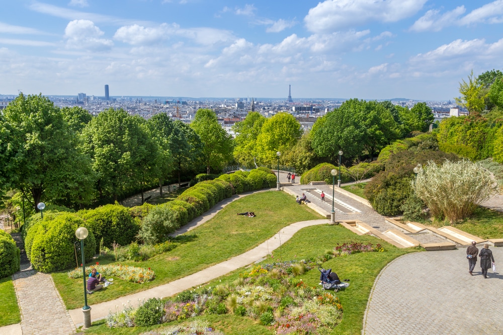 Uitzicht op een groen park de daarachter gelegen stad Parijs met de Eifeltoren in het midden.