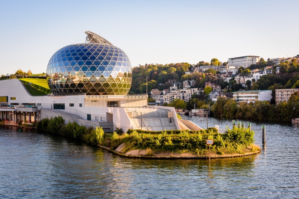 Bijzonder rondvormig modern gebouw gelegen op een groen eilandje in rivier de Seine.