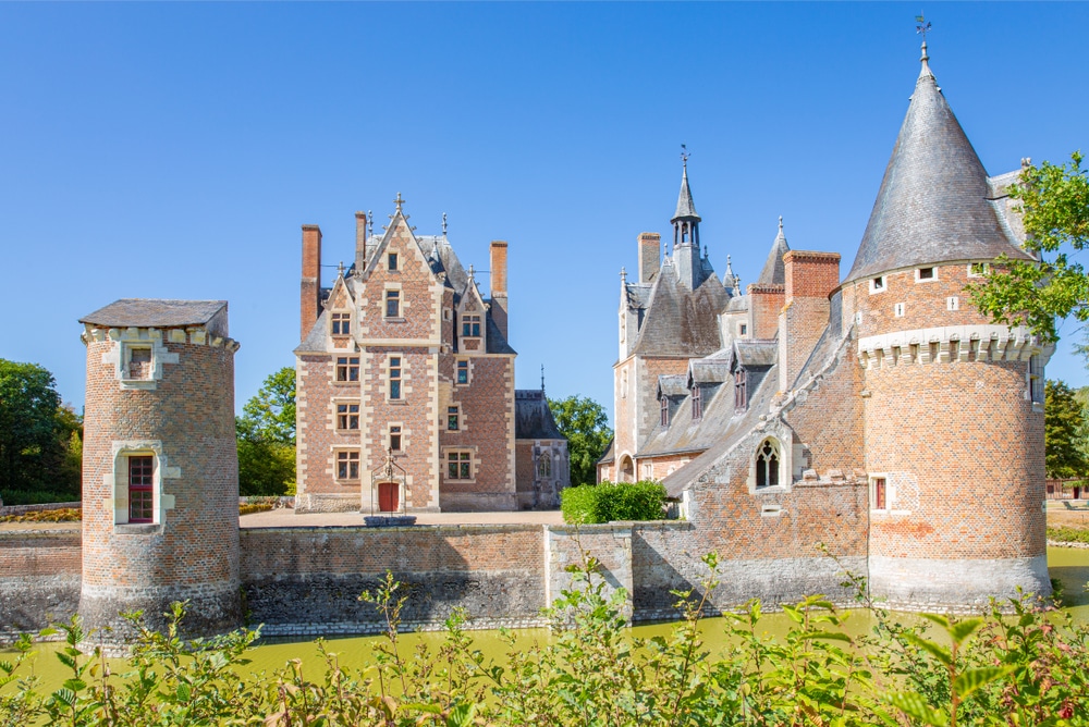 Het roodgekleurde stenen kasteel van Lassay met puntige zwarte daken.