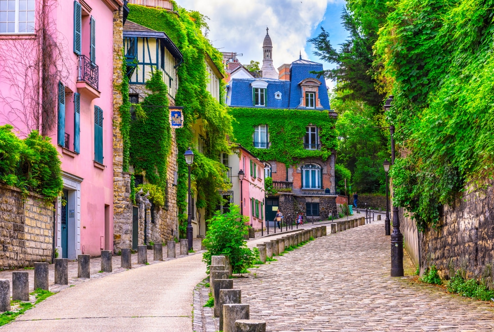 Kleurrijke huisjes met beplanting gelegen aan een stenen straatje in de wijk Montmartre