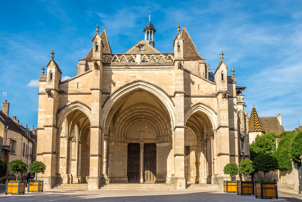 de voorkant van de Notre-Dame de Beaune, een kerk met een prachtig hoofdportaal met drie bogen