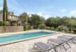 vier lege zonnebedjes aan een leeg zwembad bij een vakantiehuis in Plan de la Tour, Zuid-Frankrijk