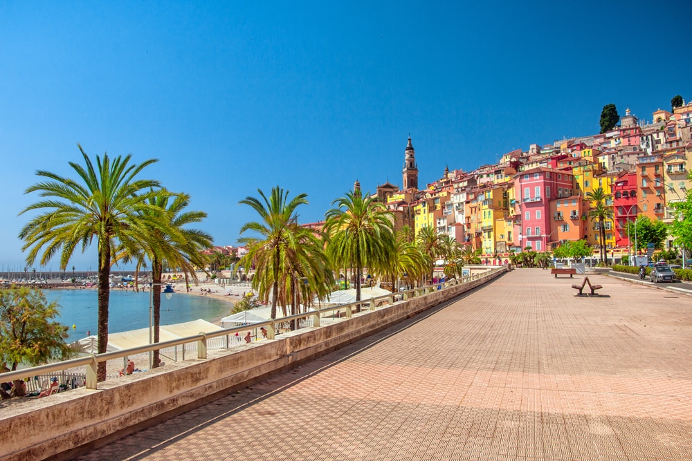 lege boulevard van Menton met daarachter kleurrijke huisje en het strand