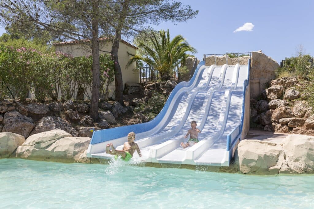 twee jongetjes die van een vierdubbele waterglijbaan afglijden op RCN Vakantiepark Domaine de Noguiere