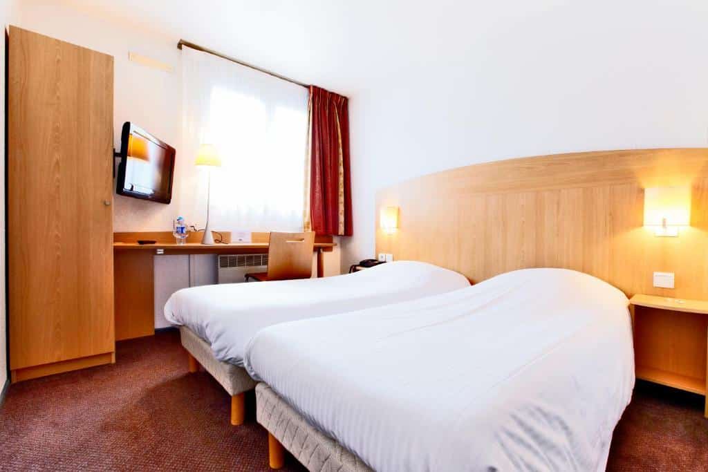 hotel kamer met twee opgemaakte eenpersoonsbedden in het Hotel Kyriad aan de rand van Mulhouse