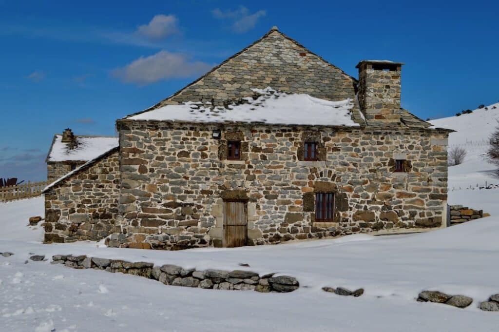 Een oude boerderij van steen in de sneeuw