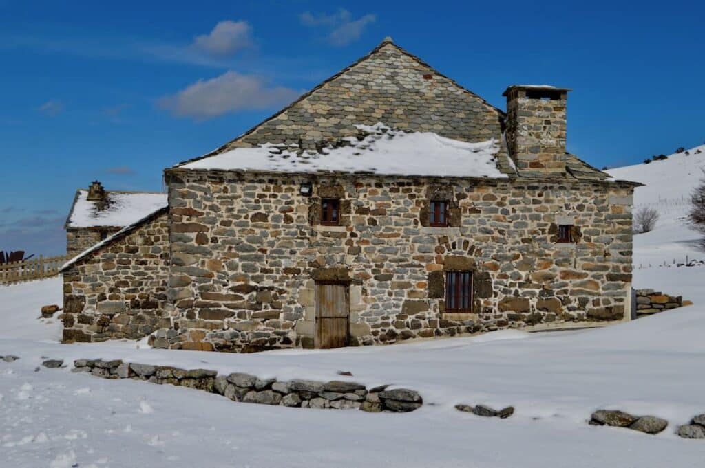 Een oude boerderij van steen in de sneeuw