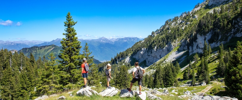 drie toeristen/wandelaars op een berg in het Massif des Bauges