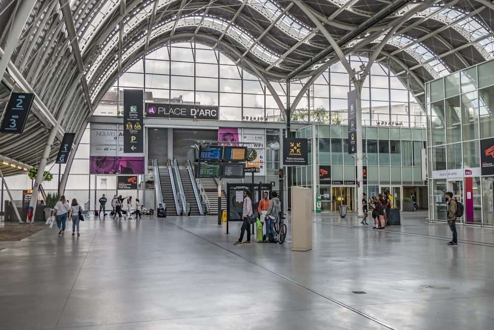 het treinstation van Orleáns waar meerdere reizigers lopen en staan