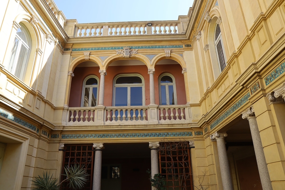 binnenplein van Hôtel Pams in Perpignan met bogen en stenen railings