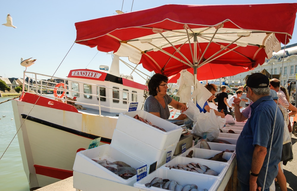 mensen op de vismarkt in de haven van Trouville-sur-Mer